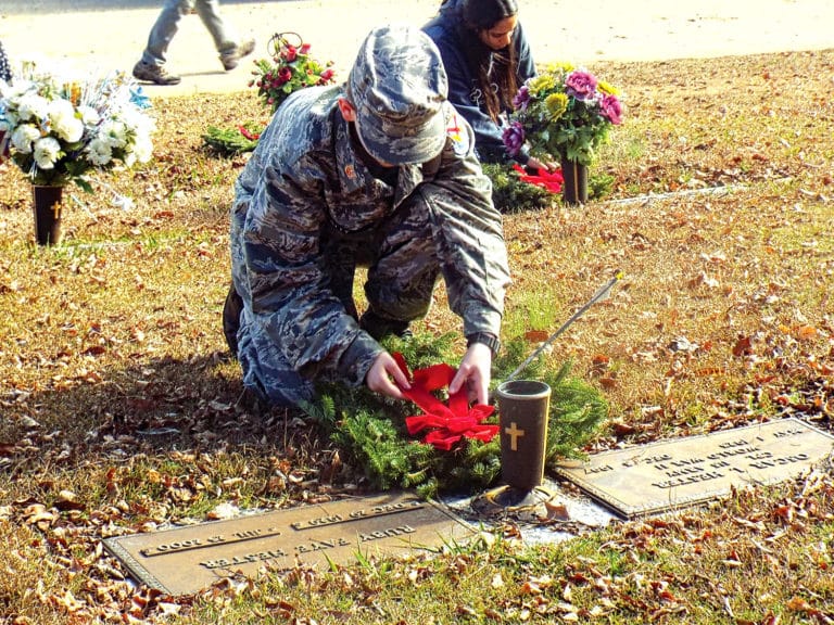 Members of the Gadsden Composite Squadron of Civil Air Patrol place wreaths on the graves of United States Military veterans in Crestwood Memorial Cemetery.