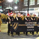 Members of the Glencoe High School Yellow Jacket Band carry a banner and march in the City of Gadsden Christmas parade.