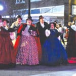 Festively costumed carolers sing during the City of Gadsden Christmas parade.