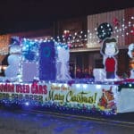 Etowah Used Cars tows a Peanuts-themed float decorated with character standees during the Attalla Christmas parade.
