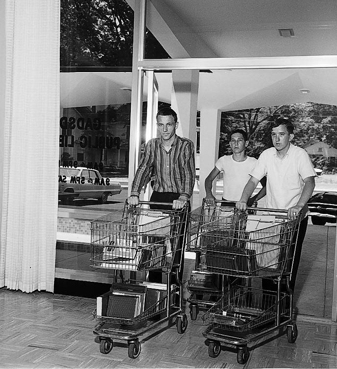 gpl_James Hill, Vernon Wise, Ronnie Leftwich move books in shopping carts, 1964
