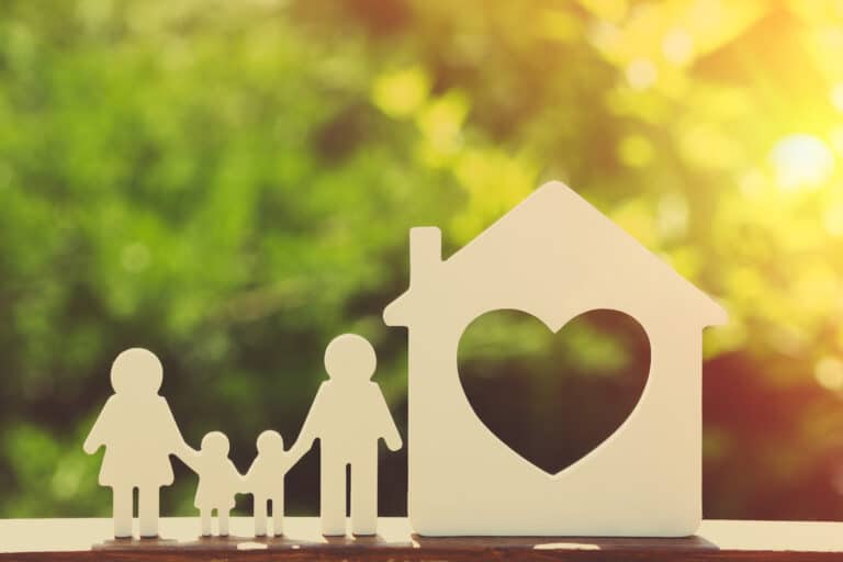 Small model of house and family on nature background