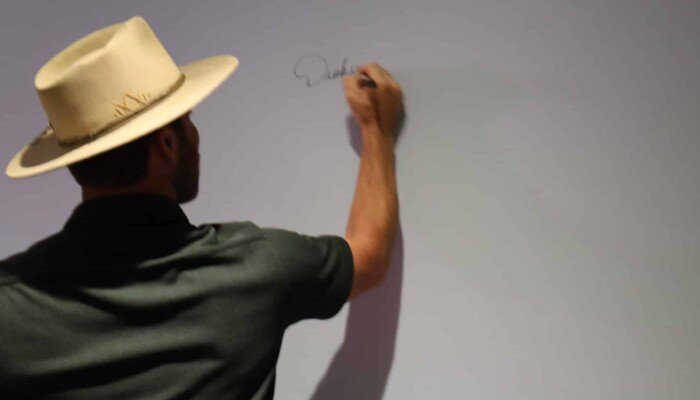 Country music singer and co-owner of The Bluff, Drake White, writing the first signature on the new signature wall.